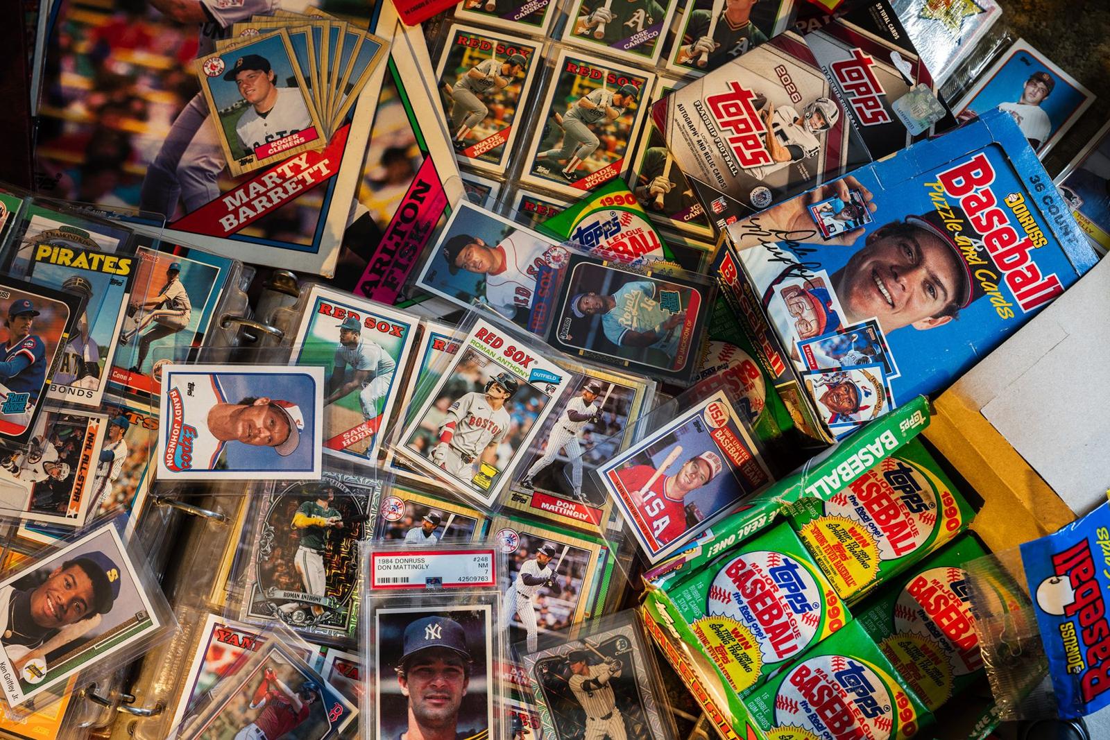 Baseball cards and unopened wax packs from the late 1980s spread across a table